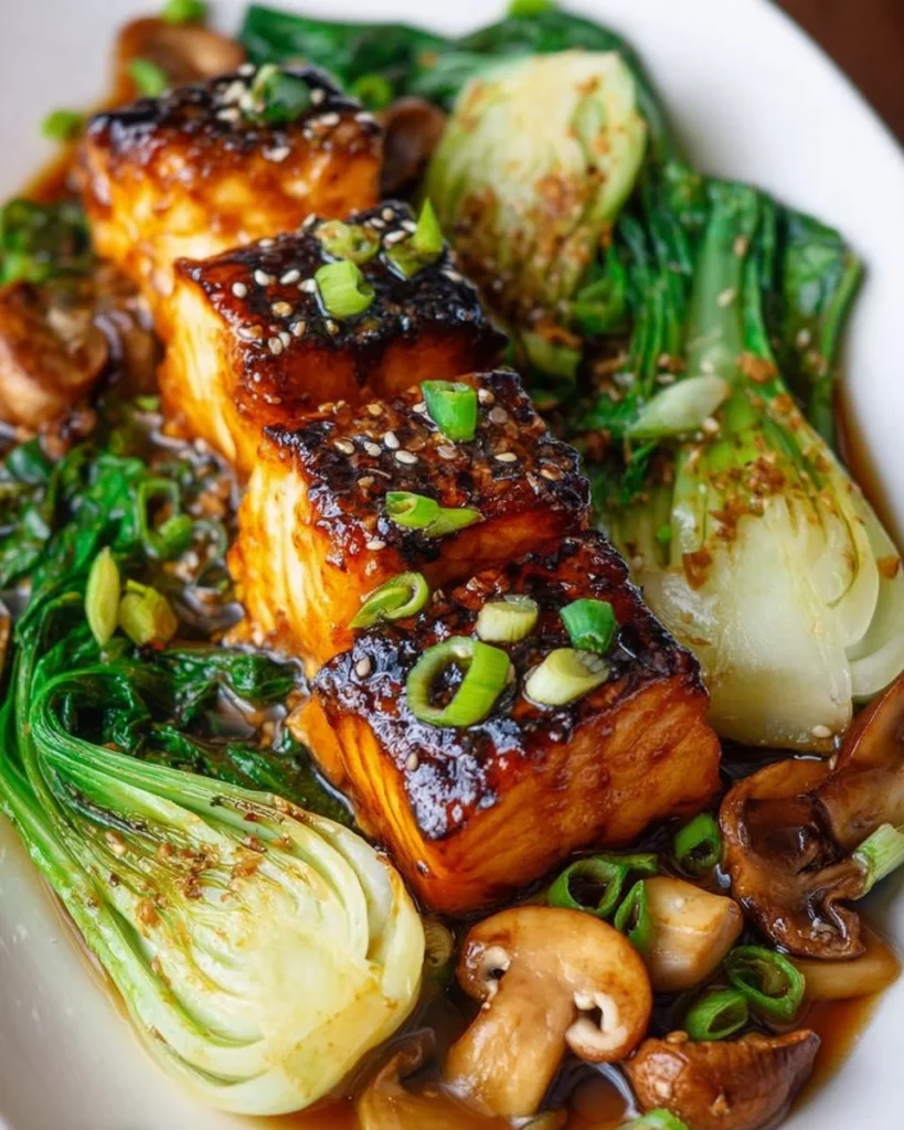 Miso glazed black cod on baby bok choy and shiitake mushrooms served on a plate