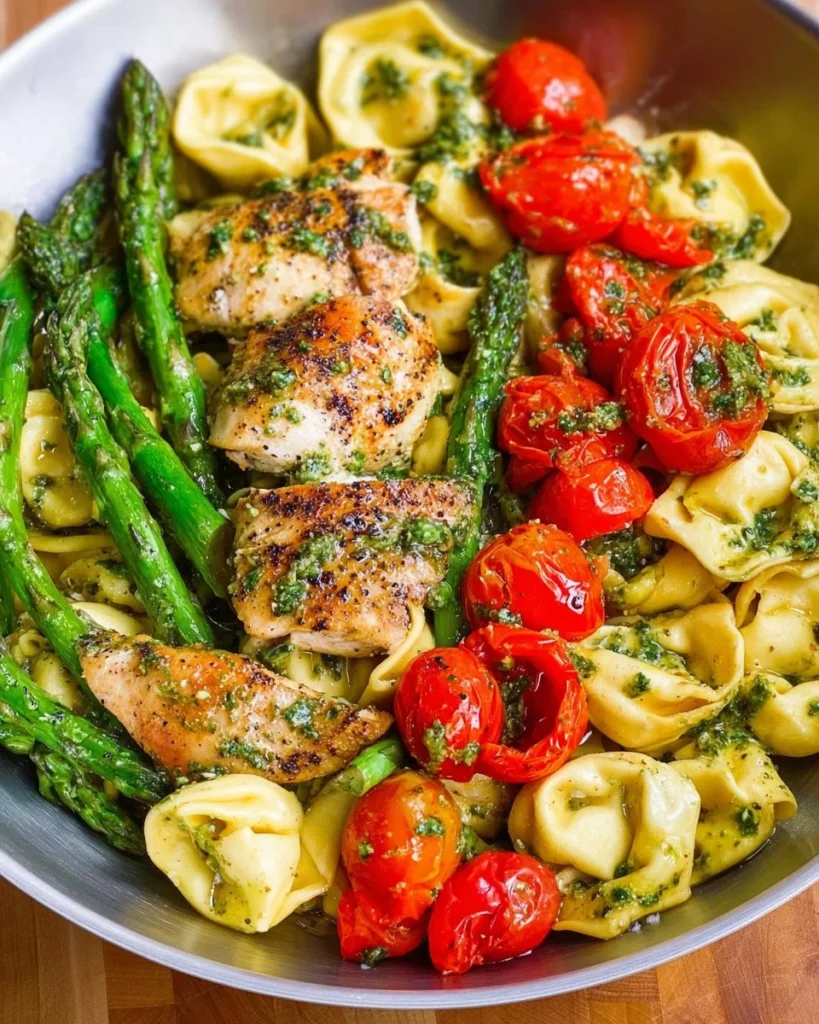 One-Pan Pesto Chicken with tortellini and fresh veggies in a skillet