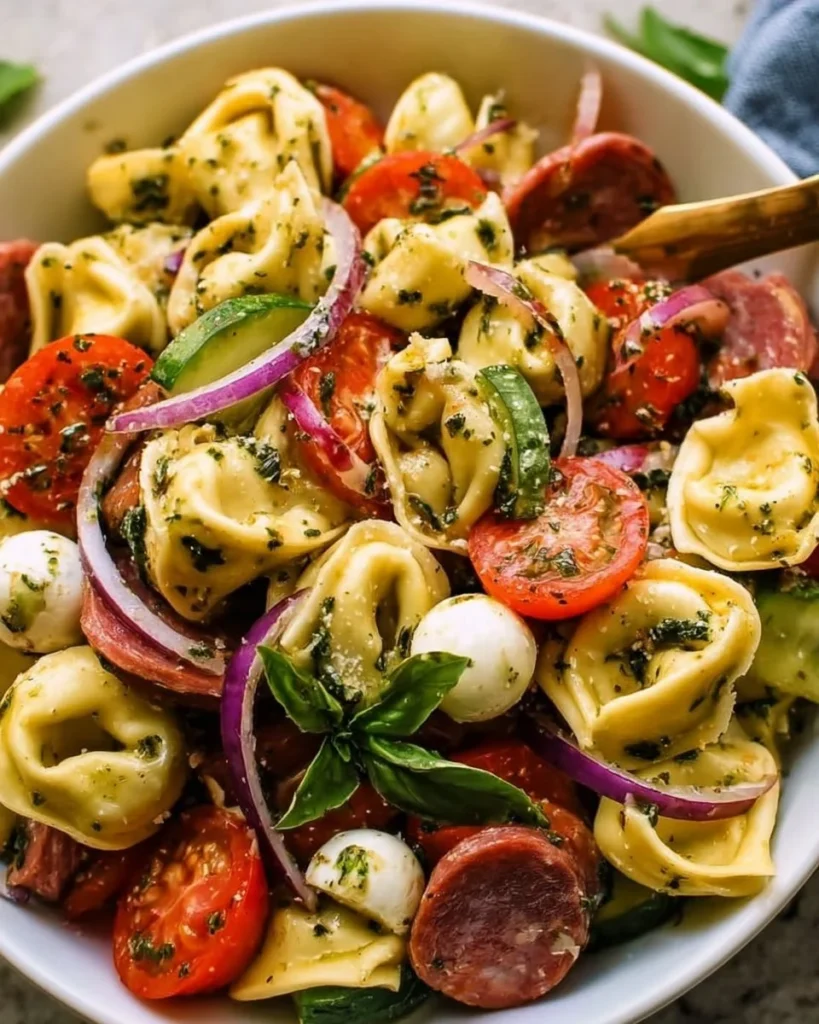 Colorful antipasto tortellini salad with vegetables and dressing in a bowl