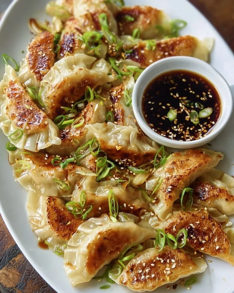 Plate of homemade Garlic Ginger Chicken Potstickers with dipping sauce.
