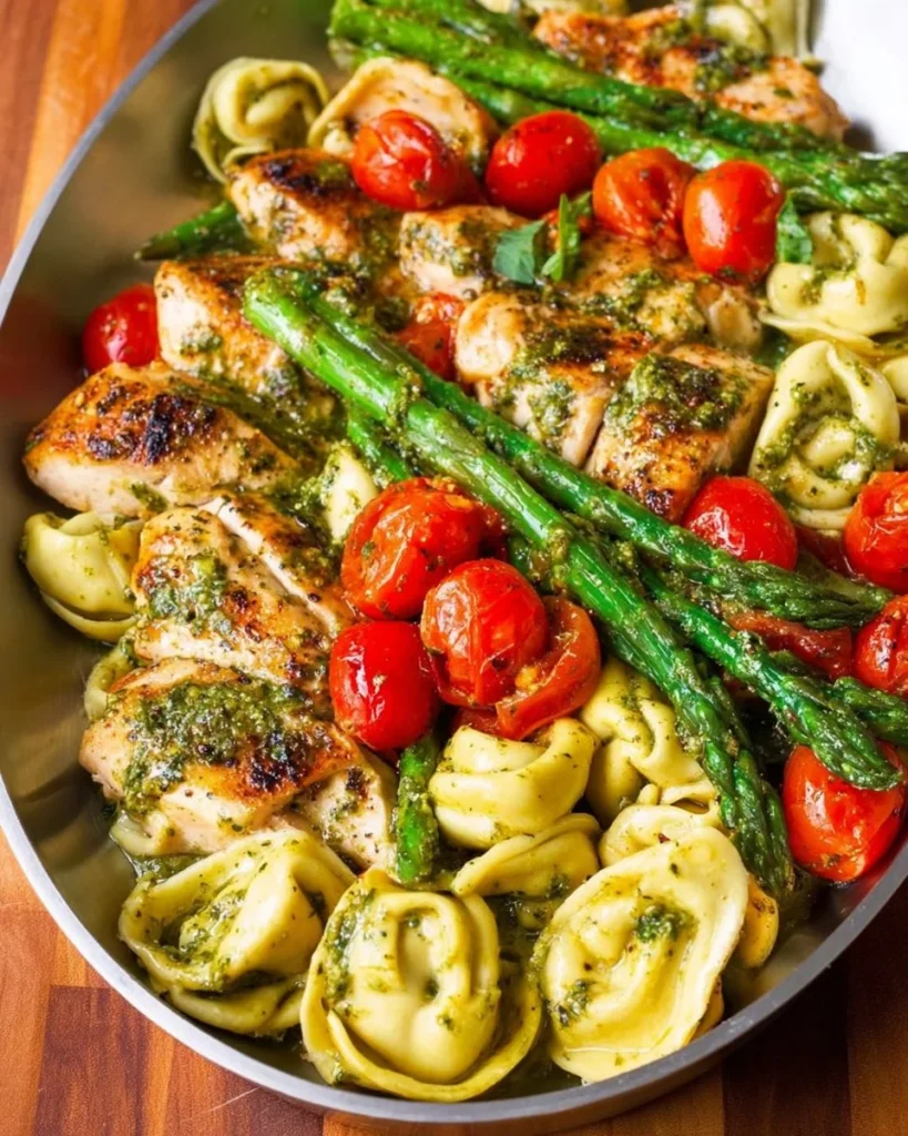 One-pan pesto chicken with tortellini and fresh veggies in a skillet